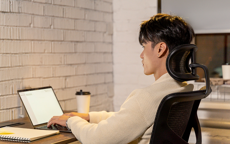 Office professional working with good posture in ergonomic chair.