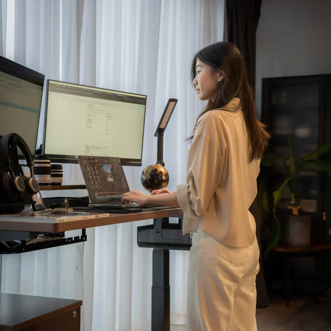 a working woman using a standing desk with adjustable height