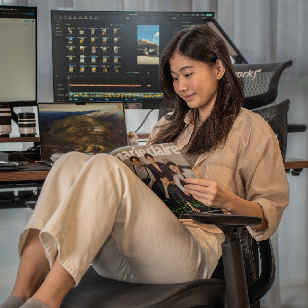 Happy woman reading while sitting on a comfortable desk chair in Singapore