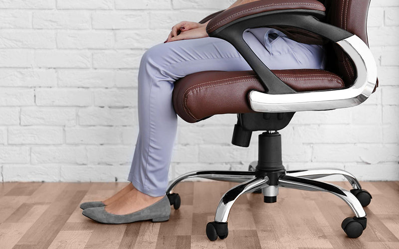 Office worker sitting with feet flat for joint comfort.