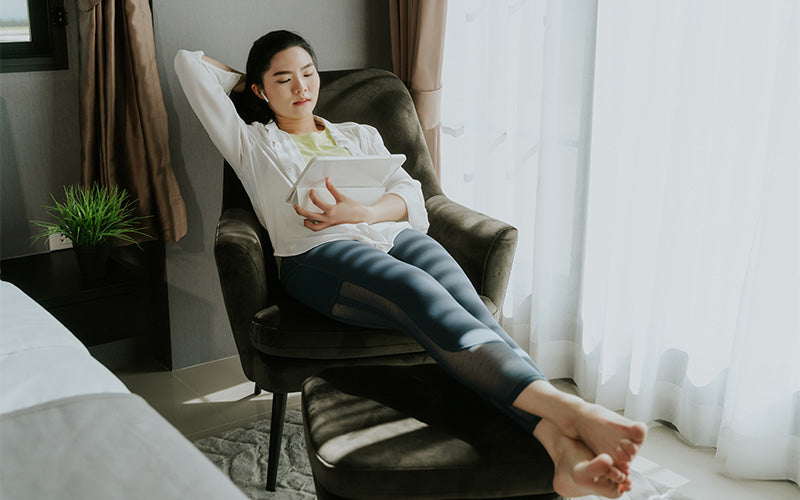 Woman using tablet in unsupported seating during leisure time.