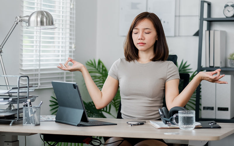 Worker practicing desk-based meditation to relieve upper body tension.