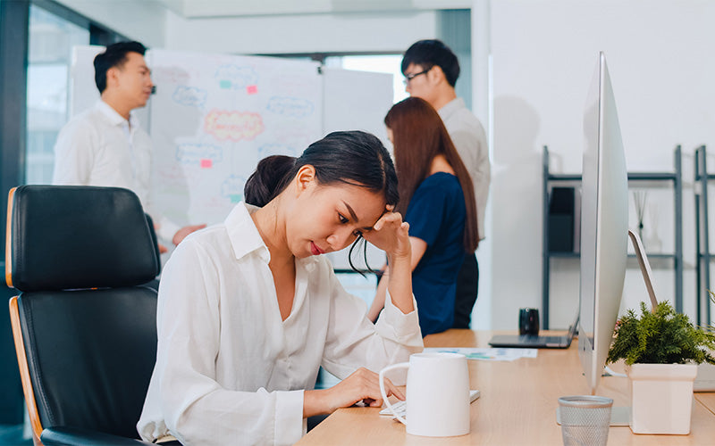 Office employee experiencing mental fatigue during a workplace meeting.